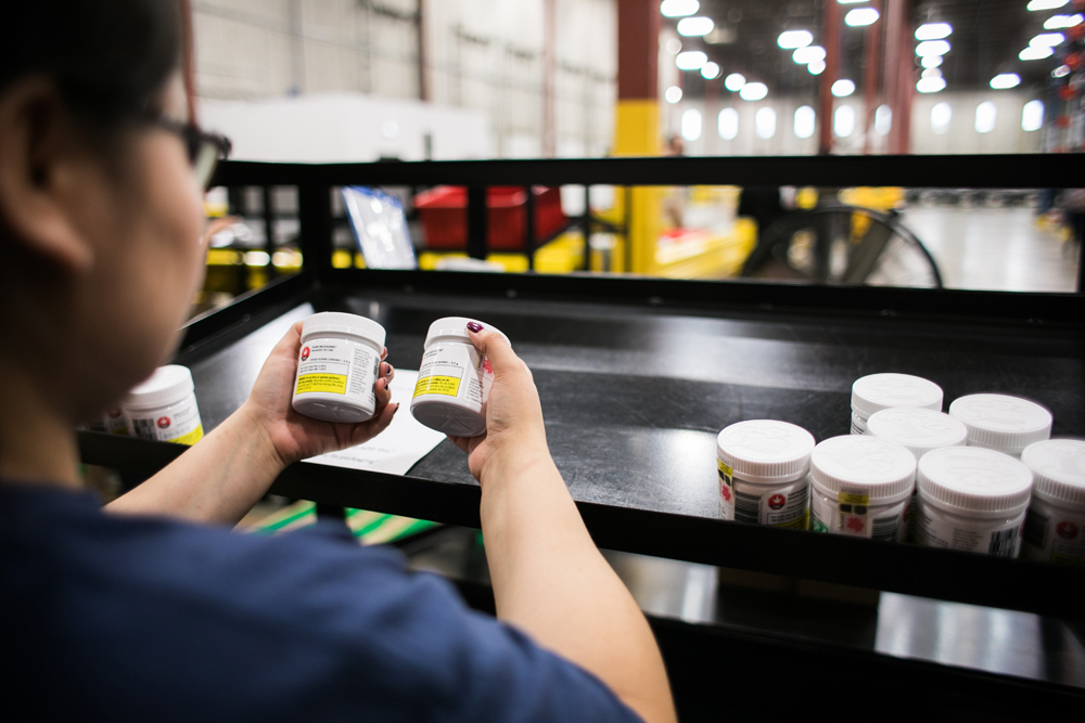 A worker sorts jars of cannabis at the Ontario Cannabis Stores' warehouse in this handout image. 