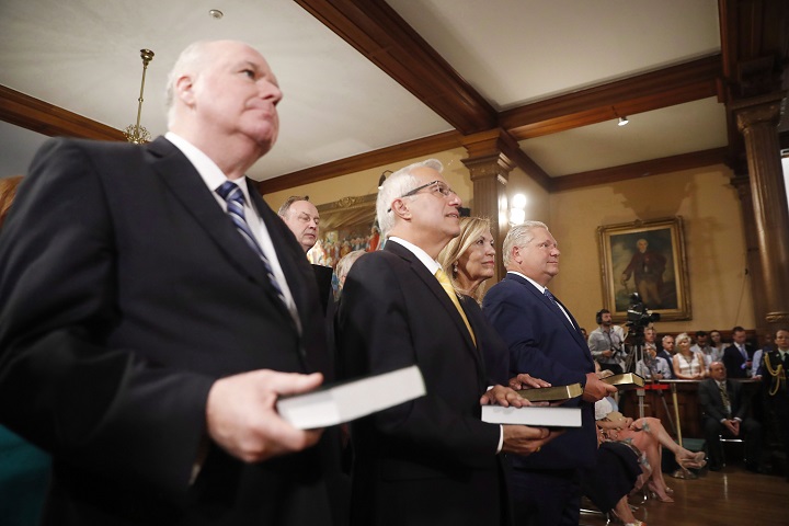 Doug Ford (right) is sworn in as premier of Ontario during a ceremony at Queen’s Park in Toronto on Friday, June 29, 2018. Cabinet ministers Jim Wilson (left to right), Vic Fedeli and Christine Elliott look on.