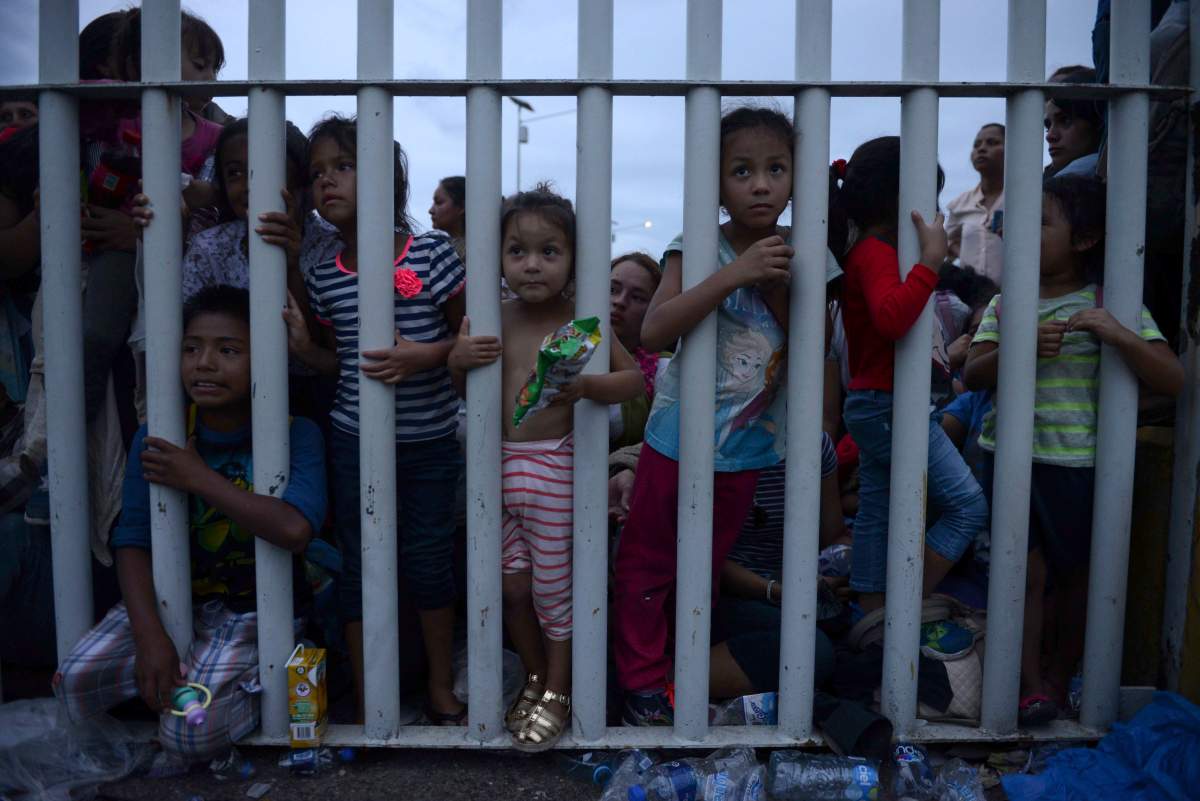 Migrant children bound for the U.S.-Mexico border wait on a bridge that stretches over the Suchiate River, connecting Guatemala and Mexico, in Tecun Uman, Guatemala, Friday, Oct. 19, 2018.