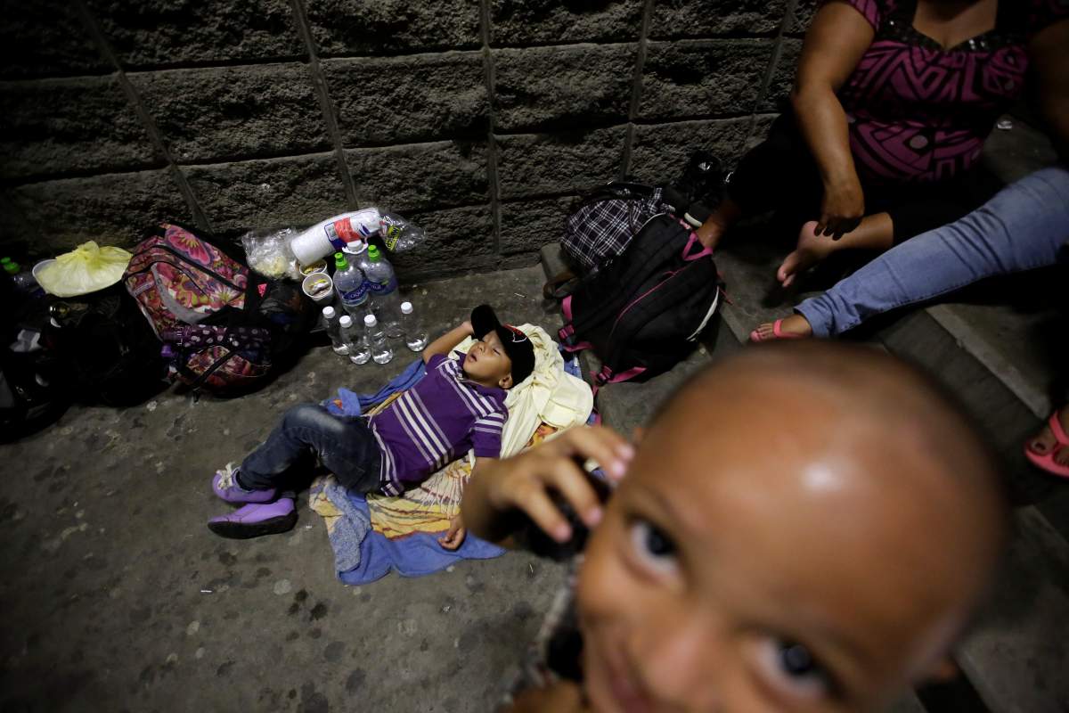 A child sleeps on the floor as their parents rest along other Hondurans fleeing poverty and violence before moving in a caravan toward the United States, outside the bus station in San Pedro Sula, Honduras, October 12, 2018.