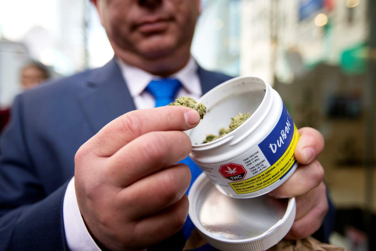 A man shows off his cannabis purchase outside the Quebec Cannabis Society (SQDC) store.