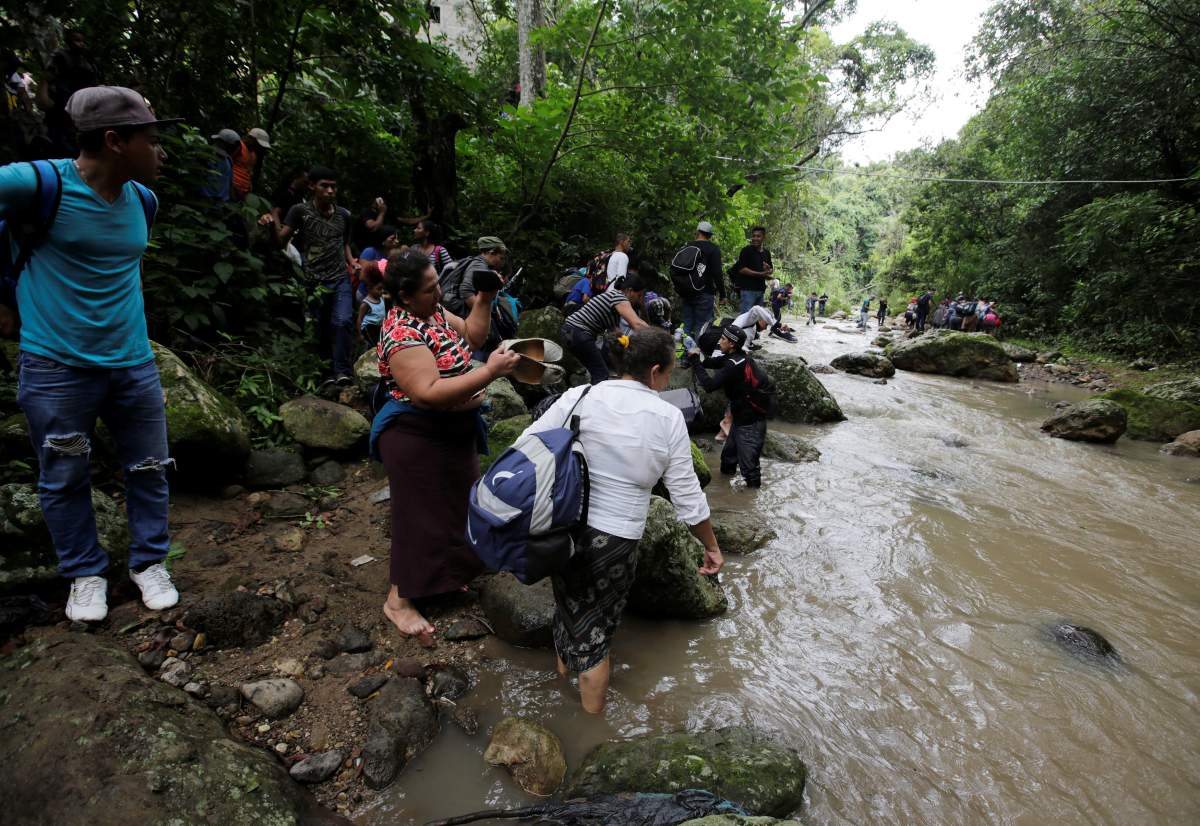 Honduran migrants cross the Lempa river in Honduras, at the border near Agua Caliente to cross into Guatemala to join a caravan trying to reach the U.S.