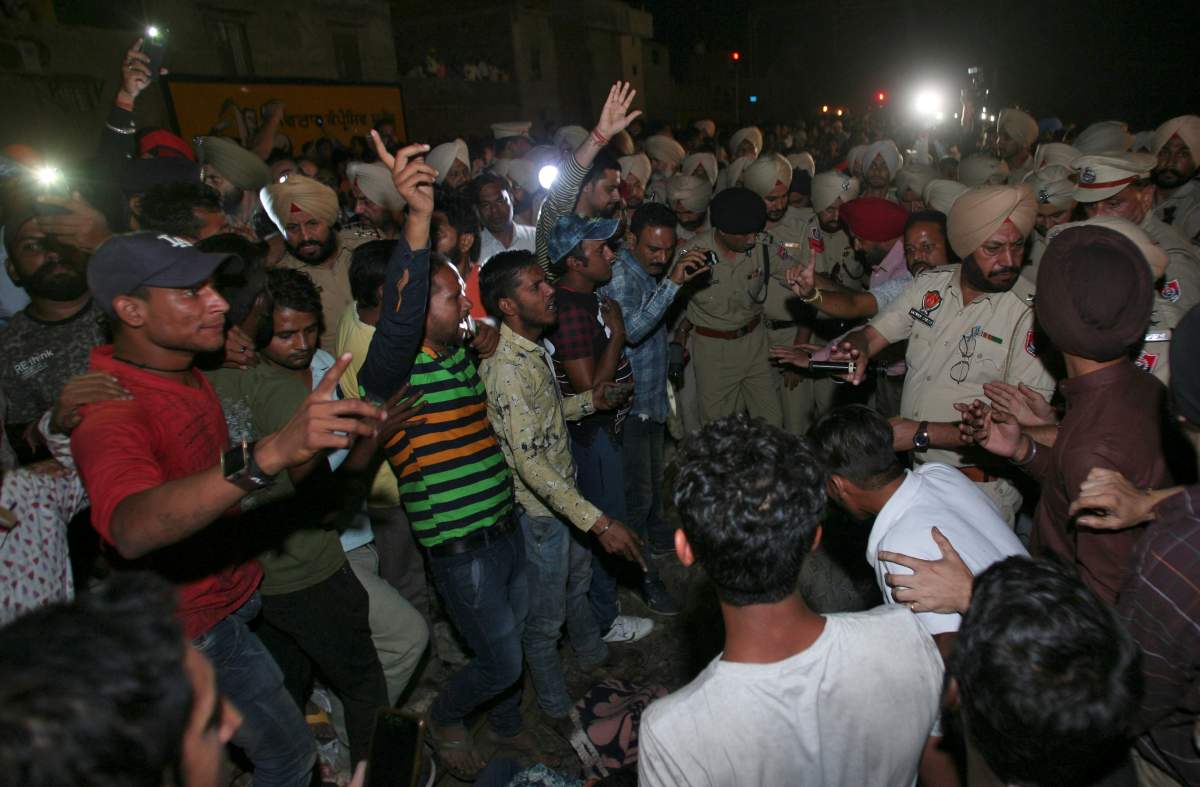 People and policemen surround the bodies victims lying on a railway track after an accident in Amritsar, India, October 19, 2018.
