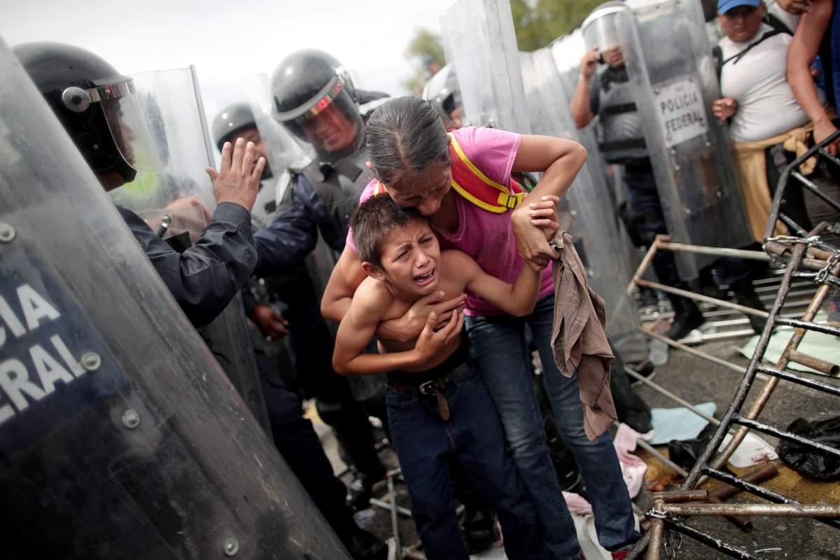 A Honduran migrant, part of a caravan trying to reach the U.S., protects her child after fellow migrants stormed a border checkpoint, in Ciudad Hidalgo, Mexico, on Oct. 19, 2018. REUTERS/Ueslei Marcelino