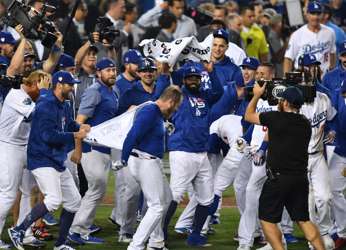 Los Angeles Dodgers first baseman Max Muncy (13) gets his jersey ripped off as he celebrates after hitting a walk off solo home run against the Boston Red Sox in the 18th inning in game three of the 2018 World Series at Dodger Stadium.