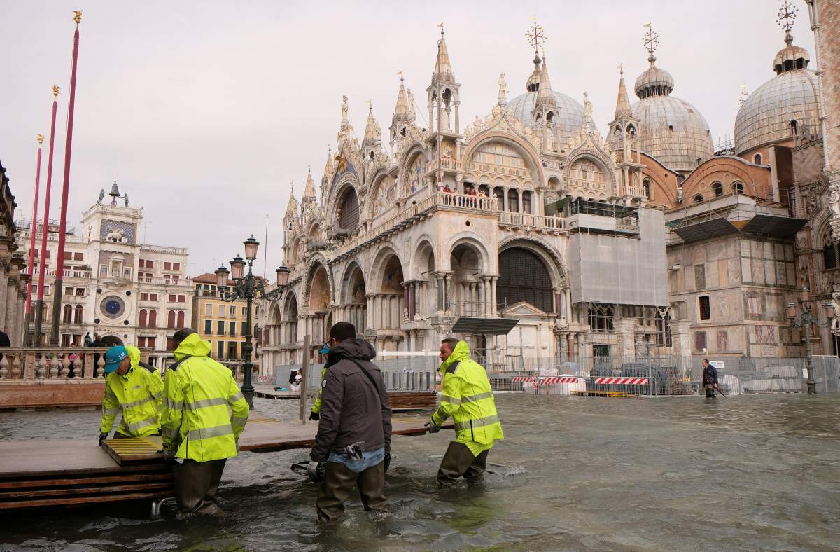 Workers prepare the catwalk in a flooded Saint Mark Square during a period of seasonal high water in Venice, Italy October 29, 2018.