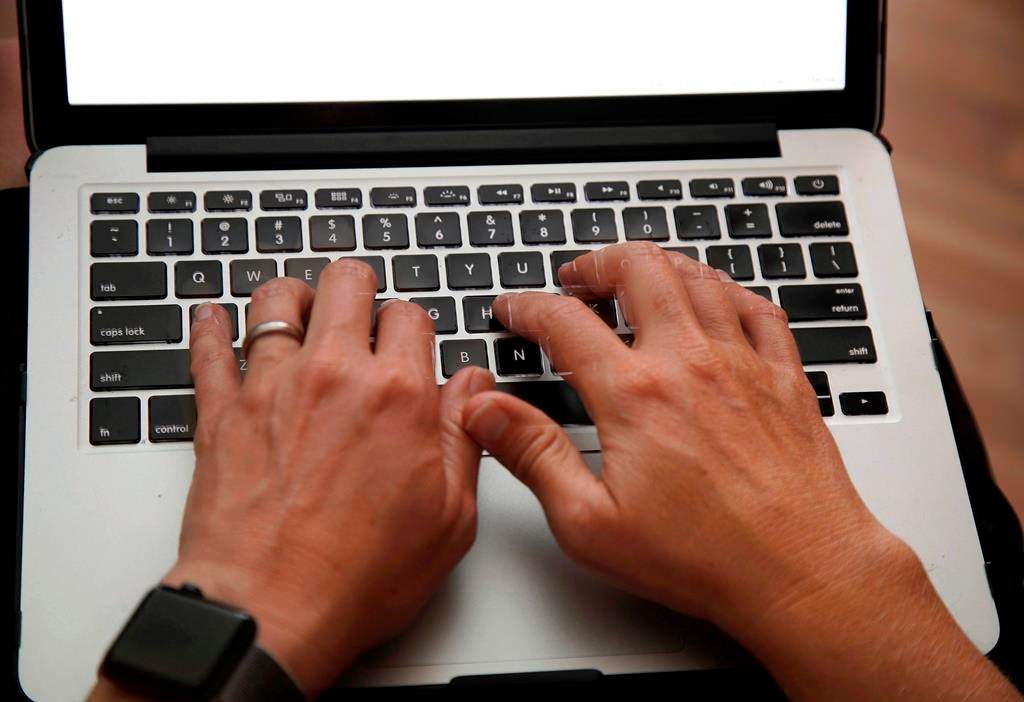 A person works on a laptop in North Andover, Mass., June 19, 2017 file photo. Statistics Canada says Canadian businesses reported spending $14 billion on cybersecurity in 2017 as they confront greater digital risks. THE CANADIAN PRESS/AP/Elise Amendola.