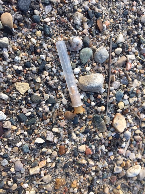 A discarded needle lies on the ground outside a building near Rosser Avenue in Brandon.