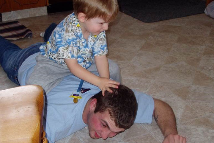 Jacob Cenerini-Palmer, 3, sitting on Pte. Thomas Welch’s back (in March 2004). Thomas was 22 when he died by suicide.