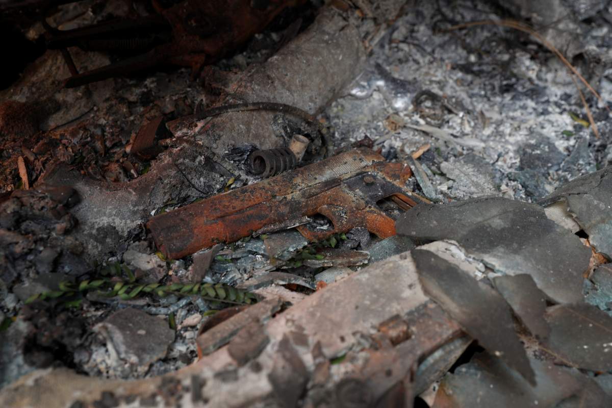 A burned handgun is seen amongst the charred wreckage of an abandoned vehicle during the Camp Fire in Paradise, California, U.S. November 9, 2018.
