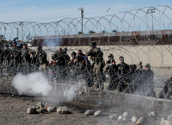 U.S. soldiers and U.S. border patrol agents fire tear gas toward migrants from the U.S. side of the border fence between Mexico and the United States in Tijuana, Mexico, Nov. 25, 2018.