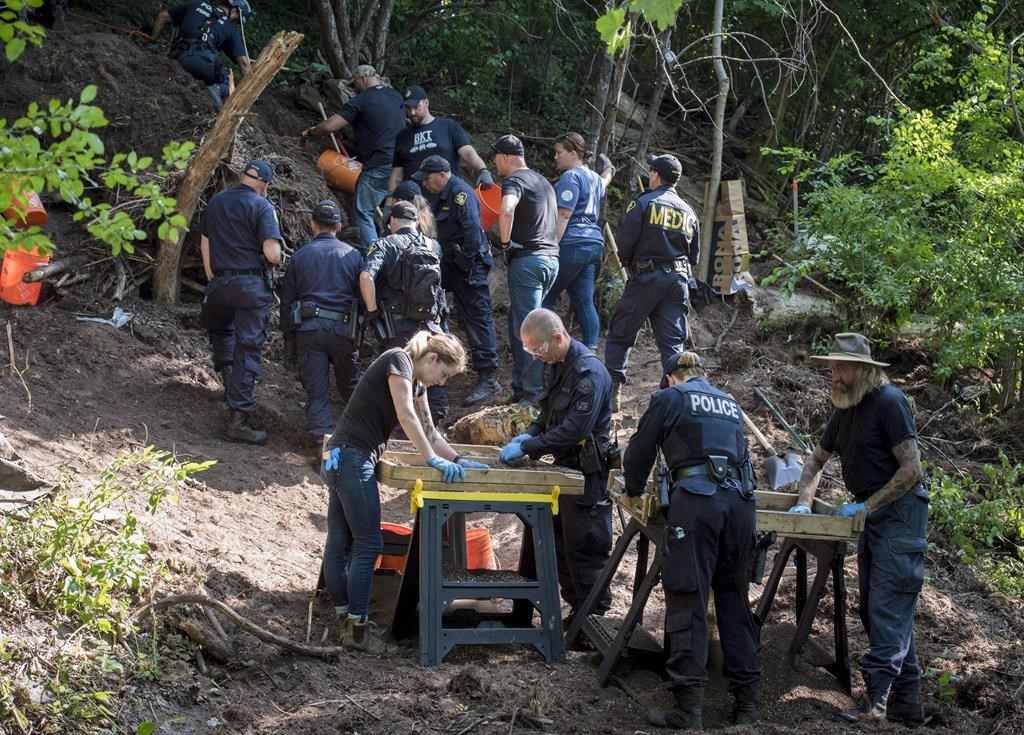 Members of the Toronto Police Service sift and excavate materials from the back of property along Mallory Cres. in Toronto after confirming they have found human remains during an investigation in relation to alleged serial killer Bruce McArthur on July 5, 2018.