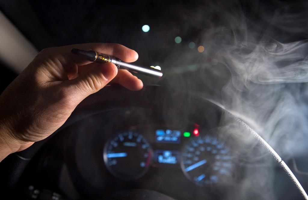 In this photo illustration, smoke from a cannabis oil vaporizer is seen as the driver is behind the wheel of a car in North Vancouver, B.C. Wednesday, Nov. 14, 2018. Canadian police have not seen a spike in cannabis-impaired driving one month since legalization, but there needs to be more awareness of laws around storing marijuana in vehicles and passengers smoking weed, law enforcement officials say.