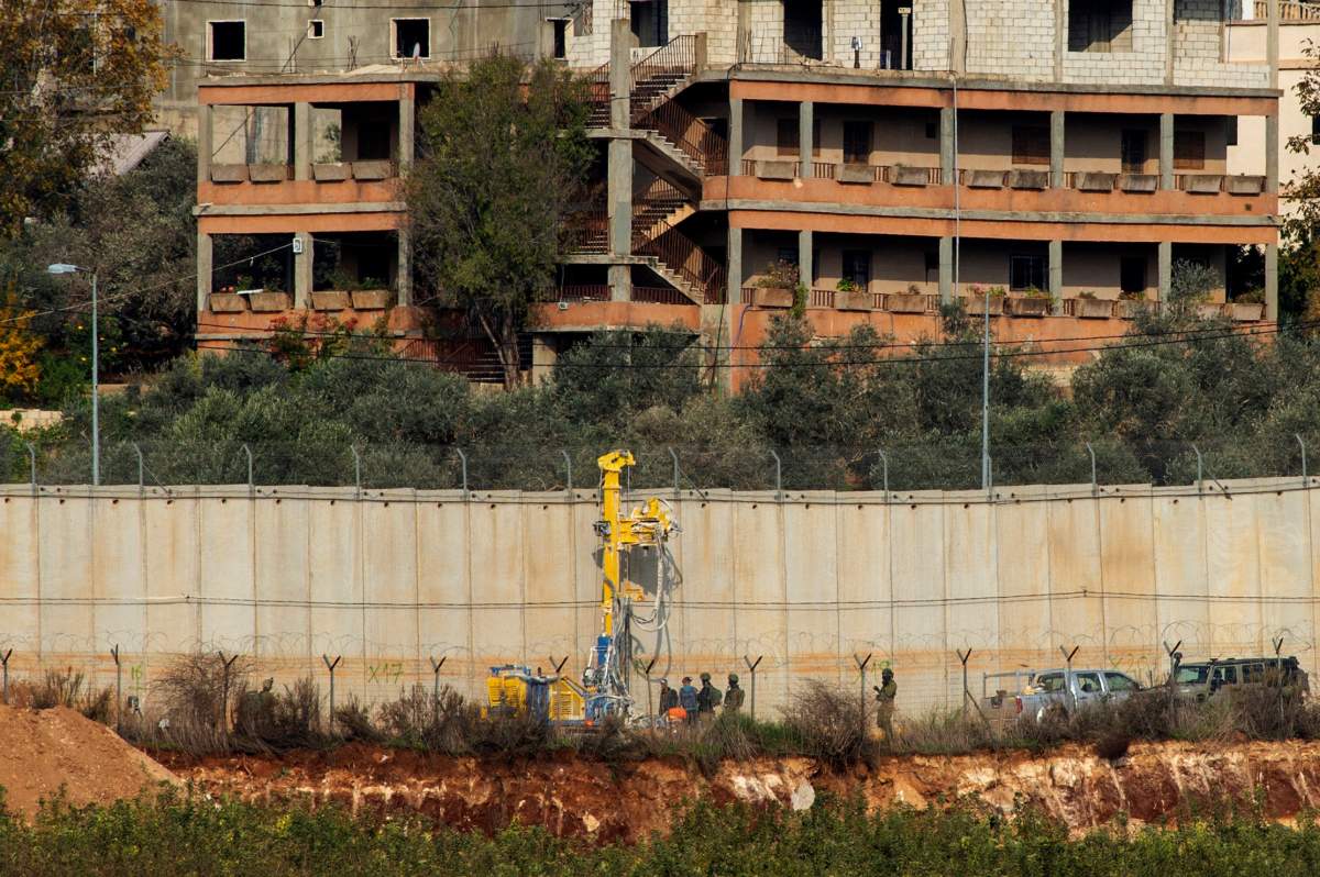 Israeli military personnel and a drill are seen as they work next to the border with Lebanon, near Metulla, northern Israel December 4, 2018.