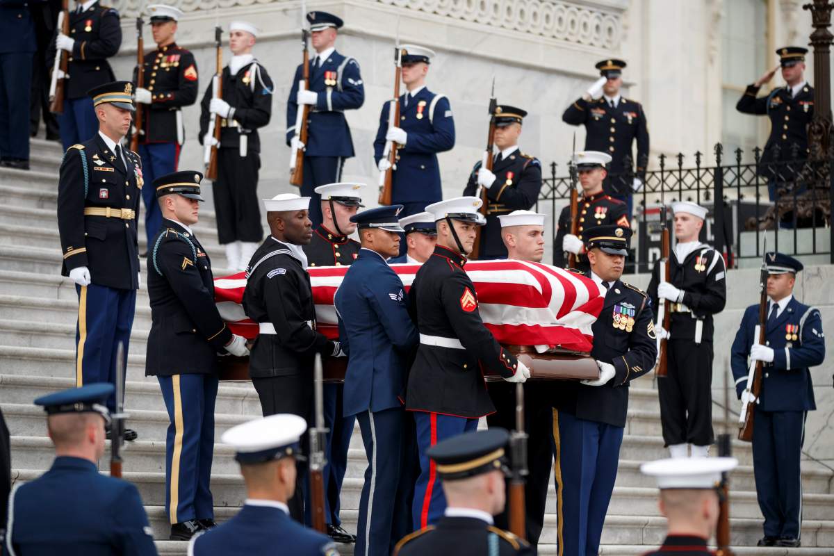 A joint service honour guard carries the casket of former U.S. President George H.W. Bush out of the US Capitol in Washington, D.C.