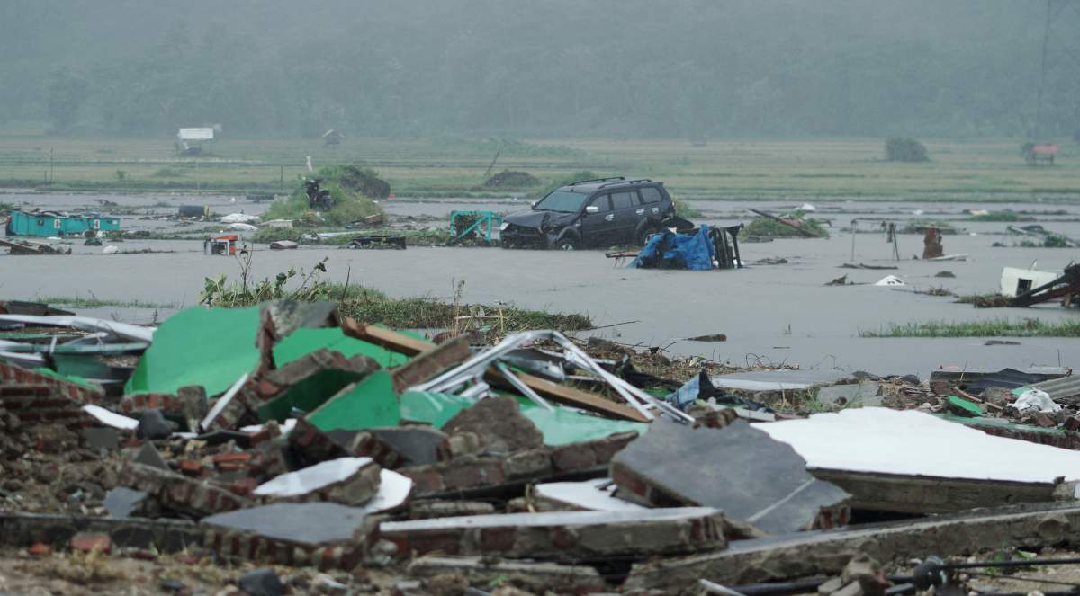 A car is seen among debris after the area was hit by a tsunami in Pandeglang, Banten province, Indonesia, Dec. 23, 2018.
