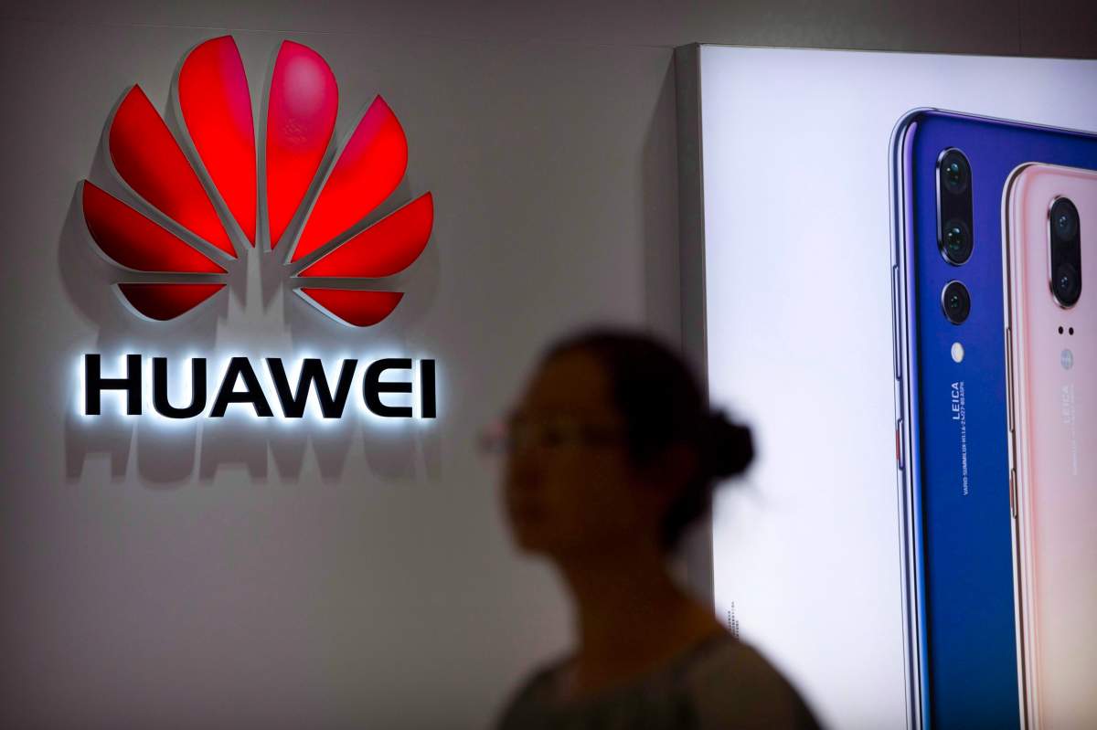 A shopper walks past a Huawei store at a shopping mall in Beijing Wednesday, July 4, 2018.