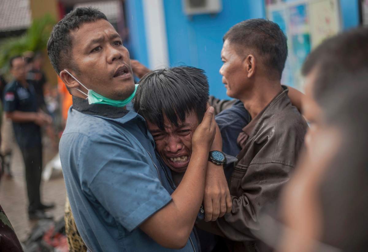 A man reacts after identifying his relative among the bodies of tsunami victims in Carita, Indonesia, Sunday, Dec. 23, 2018. T
