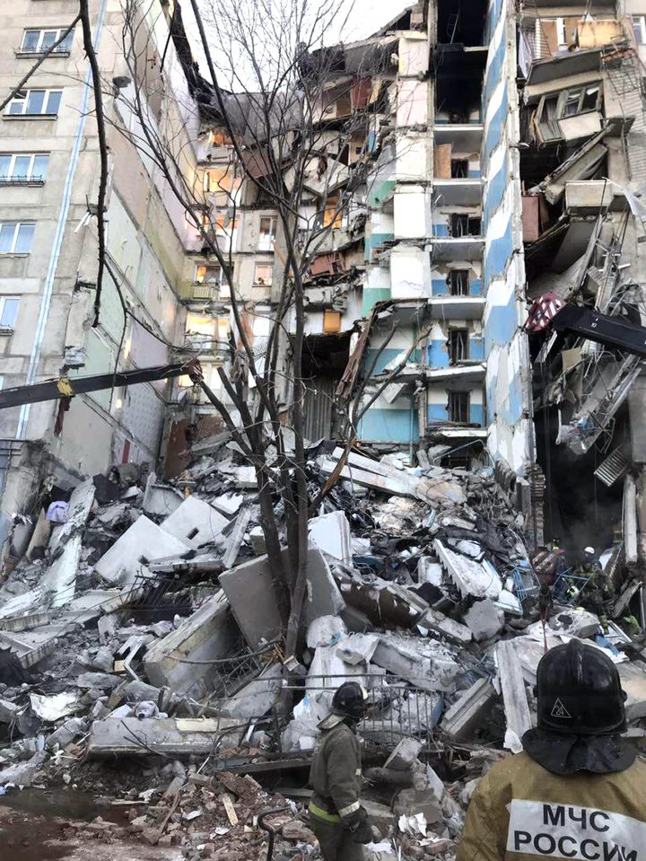 This image provided by the Russian Emergency Situations Ministry taken from TV footage, shows Emergency Situations employees working at the scene of a collapsed section of an apartment building in Magnitogorsk, Russia, Monday, Dec. 31, 2018.