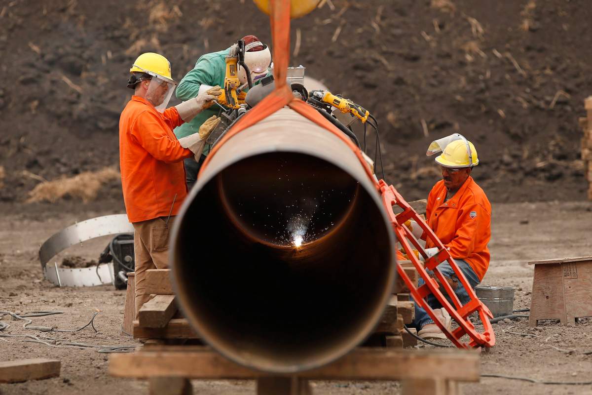 Enbridge workers weld pipe just west of Morden, Man., Thursday, Aug. 16, 2018.