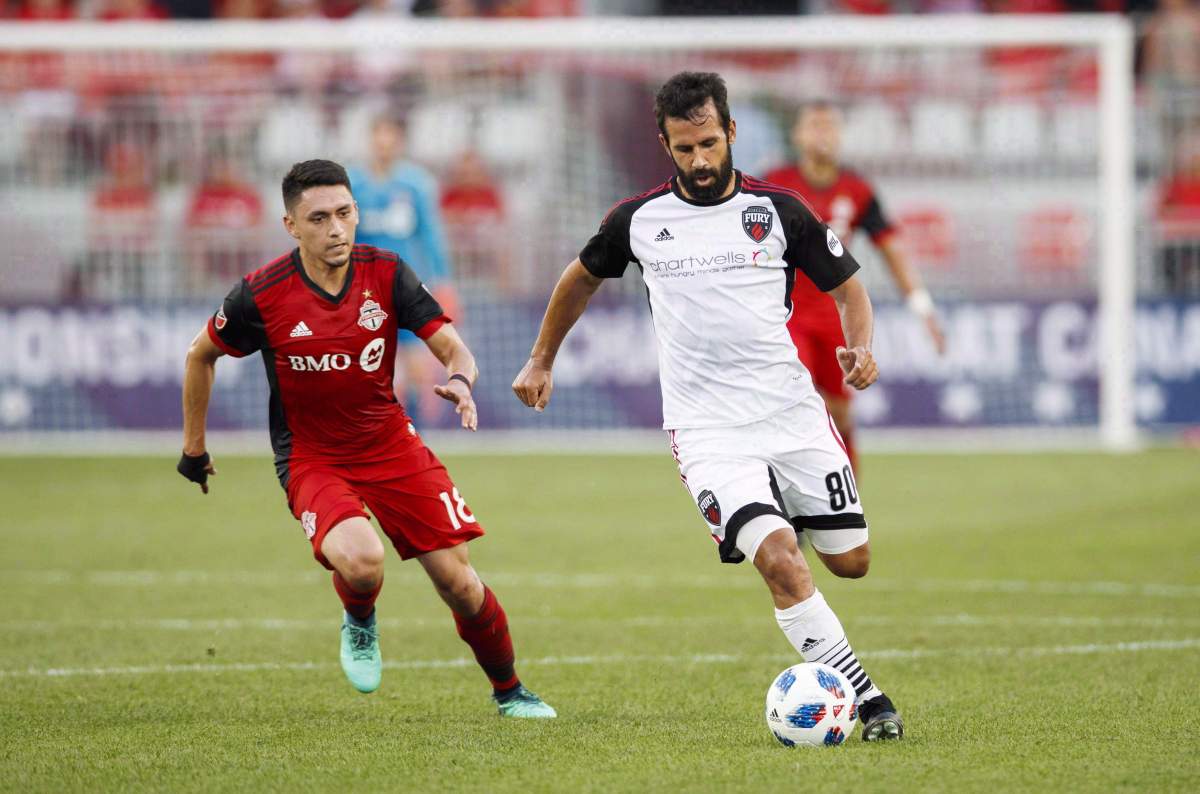 Ottawa Fury FC's Cristian Portilla battles for the ball with Toronto FC's Marco Delgado, left, during the first half of Canadian Championship soccer action in Toronto on July 25, 2018. Ottawa Fury FC is turning to the Court of Arbitration for Sport for help in its sanctioning battle with CONCACAF. The Fury, the only Canadian team left in the top tier of the United Soccer League, chose to remain in the U.S. league in 2019 rather than join the new Canadian Premier League, which is slated to kick off in April. The Ottawa team says it has received the green light from the Canada Soccer Association and the United States Soccer Federation only to have CONCACAF, which governs North and Central America and the Caribbean, say it would not sanction playing in the USL.