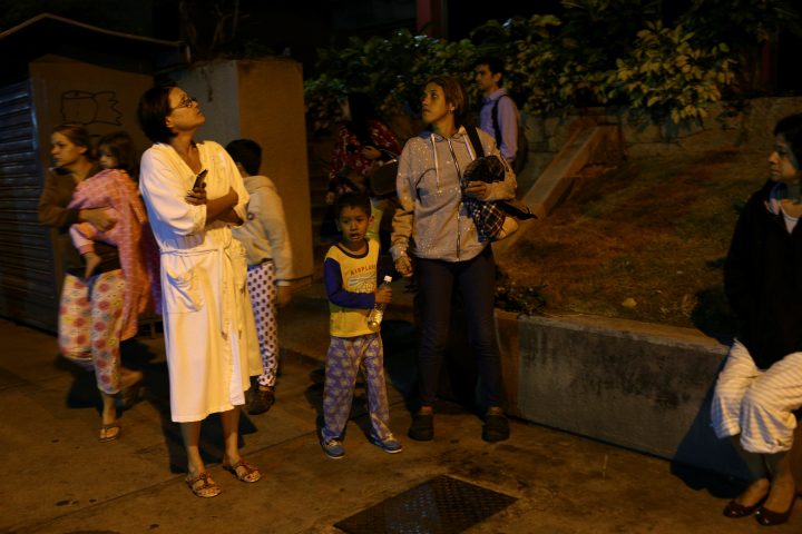 People stand on the street after an earthquake was felt across northern Venezuela, in Caracas, Venezuela December 27, 2018. 