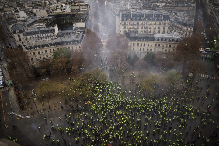 A view shows a barricade with police forces and protesters wearing yellow vests, a symbol of a French drivers protest against higher diesel taxes, during clashes as part of a demonstration near the Place de l’etoile in Paris, France, December 1, 2018.