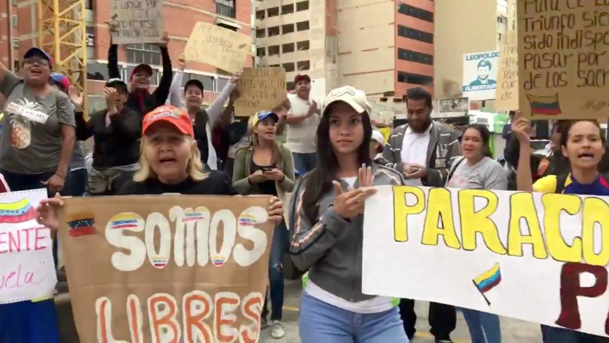 People take part in a protest in Caracas, Venezuela January 23, 2019 in this picture obtained from social media. The placard reads, “We are free”.