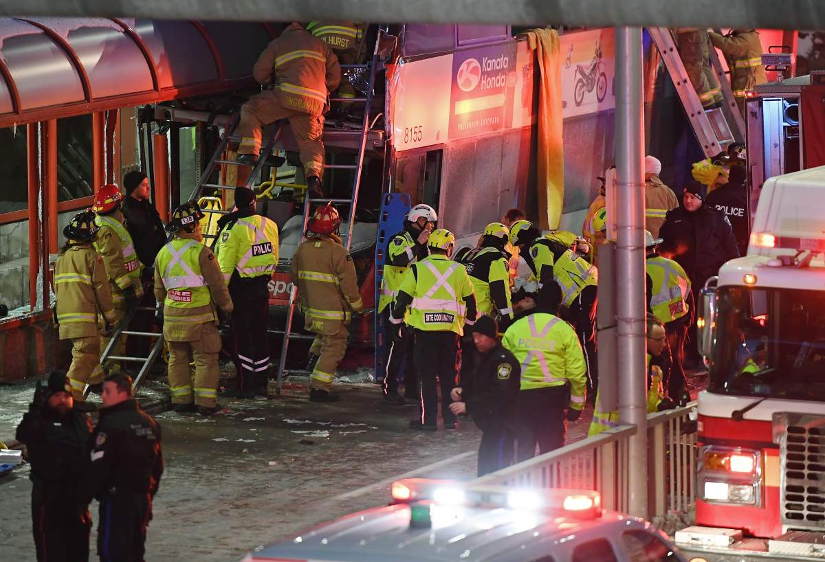 Police and first responders work at the scene where a double-decker city bus struck a transit shelter in Ottawa, on Friday, Jan. 11, 2019.