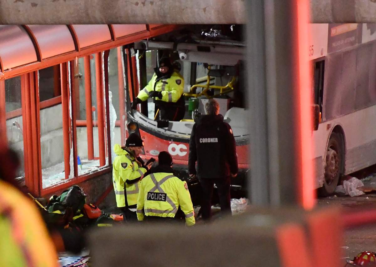 Police and a first responders work at the scene where a double-decker city bus struck a transit shelter in Ottawa, on Friday, Jan. 11, 2019.