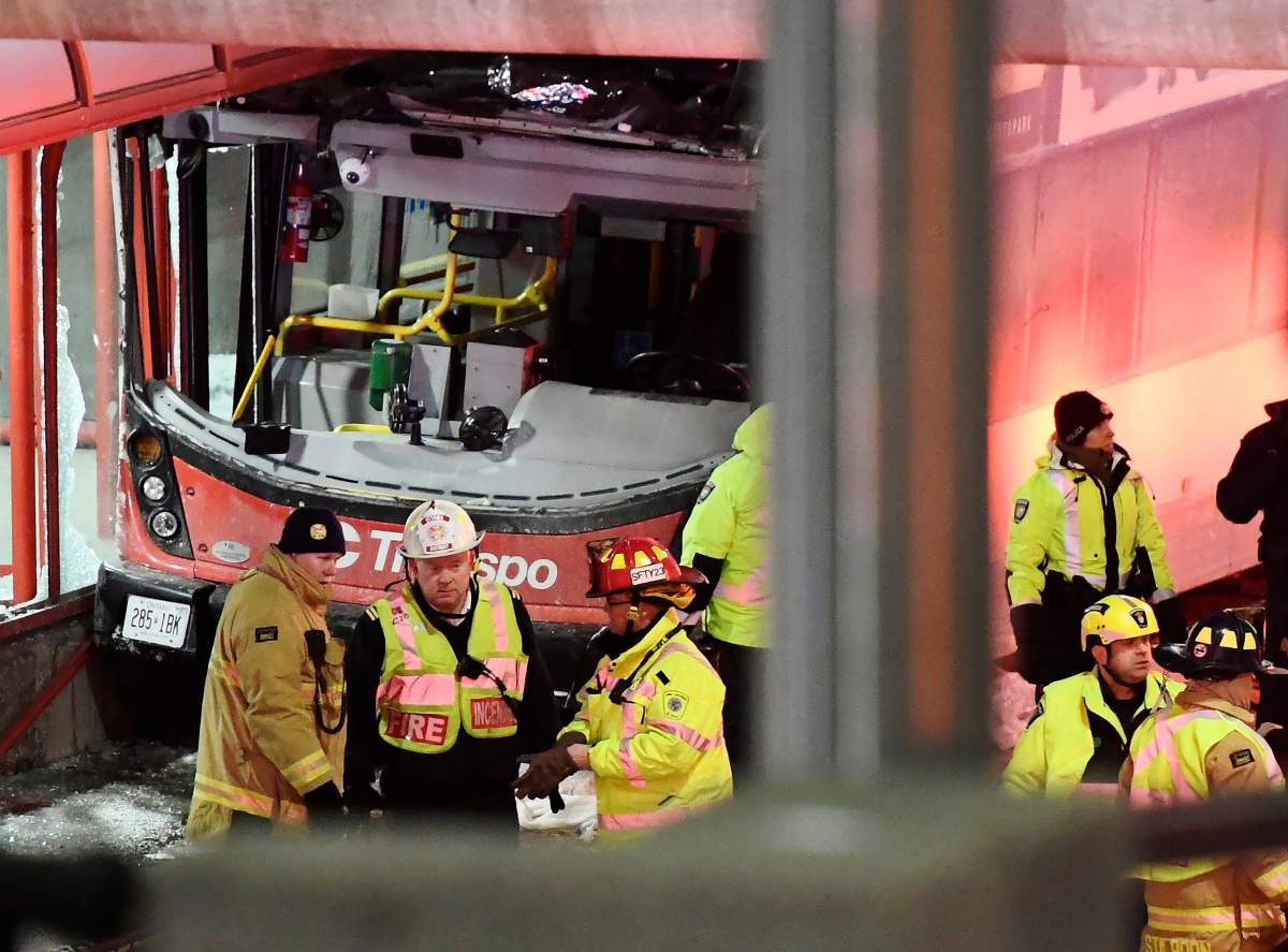 Police and first responders work at the scene where a double-decker city bus struck a transit shelter in Ottawa, on Friday, Jan. 11, 2019.