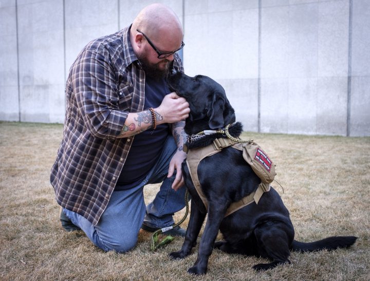 Former Syncrude firefighter Michael Swan and his service dog Jack in Calgary, Alta., Monday, Jan. 14, 2019. A lawsuit filed by a former firefighter and paramedic against Syncrude Canada claims the oilsands giant wrongfully denied him benefits and fired him after he was diagnosed with post-traumatic stress disorder related to his job.