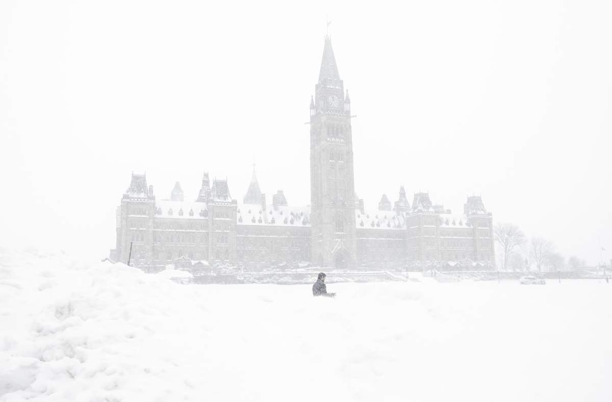 A pedestrian walks past a snowbank on Parliament Hill in Ottawa on Sunday, January 20, 2019. Environment Canada issued a winter storm warning for the city of Ottawa on Wednesday, Jan. 23, 2019.