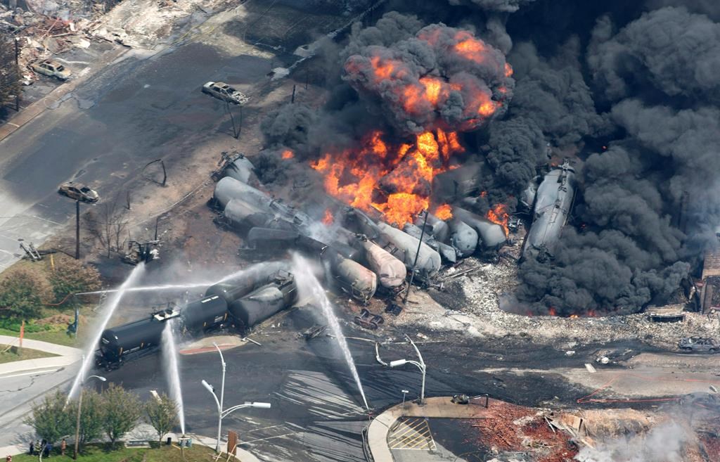 Smoke rises from railway cars that were carrying crude oil after derailing in downtown Lac-Megantic, Que., Saturday, July 6, 2013.