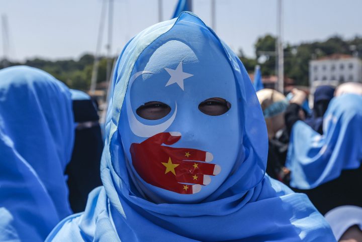 A supporter of the mostly Muslim Uighur minority wears a mask decorated in the colours of the East Turkestan flag, with a China flag-inspired hand over its mouth, at a protest in Istanbul, Turkey, on July 5, 2018.