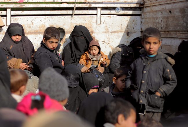 Women and children sit at a back of a bus near Baghouz, Deir Al Zor province, Syria, Feb. 11, 2019.