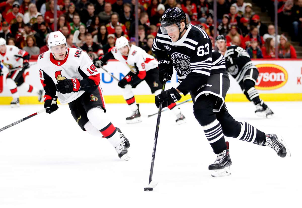 Chicago Blackhawks defenseman Carl Dahlstrom (63) skates with the puck past Ottawa Senators left wing Ryan Dzingel (18) during the first period of an NHL hockey game Monday, Feb. 18, 2019, in Chicago. (AP Photo/Jeff Haynes)