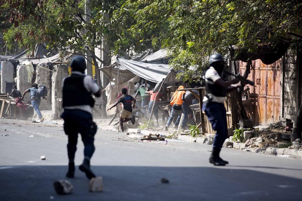 National police shoot at protesters demanding the resignation of Haitian President Jovenel Moise near the presidential palace in Port-au-Prince, Haiti, Wednesday, Feb. 13, 2019. Protesters are angry about skyrocketing inflation and the government’s failure to prosecute embezzlement from a multi-billion Venezuelan program that sent discounted oil to Haiti. (THE CANADIAN PRESS/AP, Dieu Nalio Chery)