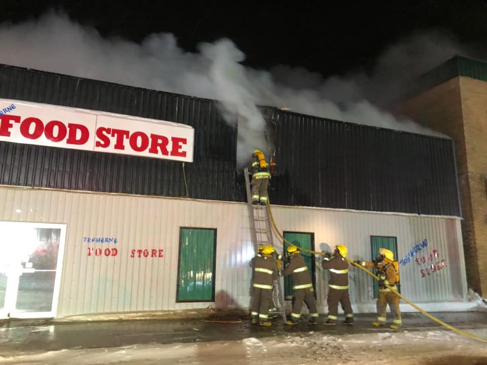 Crews work to fight the flames of the town’s local grocery store.