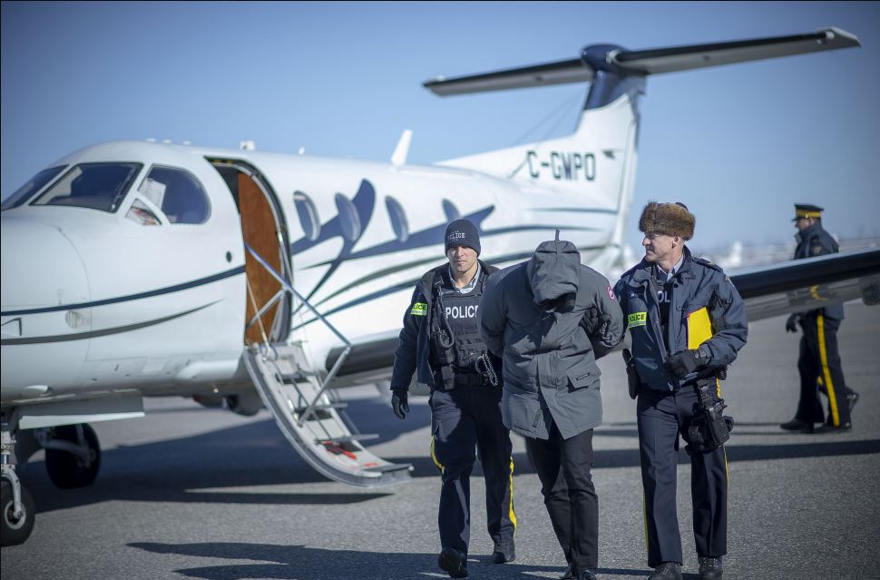 In this undated RCMP handout an individual is arrested as part of a money laundering investigation.