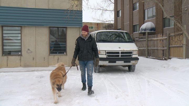 Jesse Boldt and his dog Layla walk by their converted Dodge cargo van.