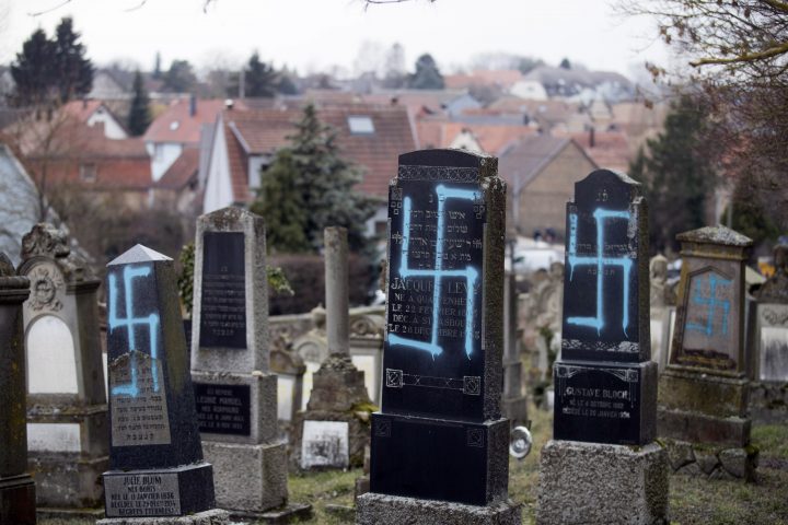 Vandalized tombs with tagged swastikas are pictured in the Jewish cemetery of Quatzenheim, eastern France, Tuesday, Feb.19, 2019.