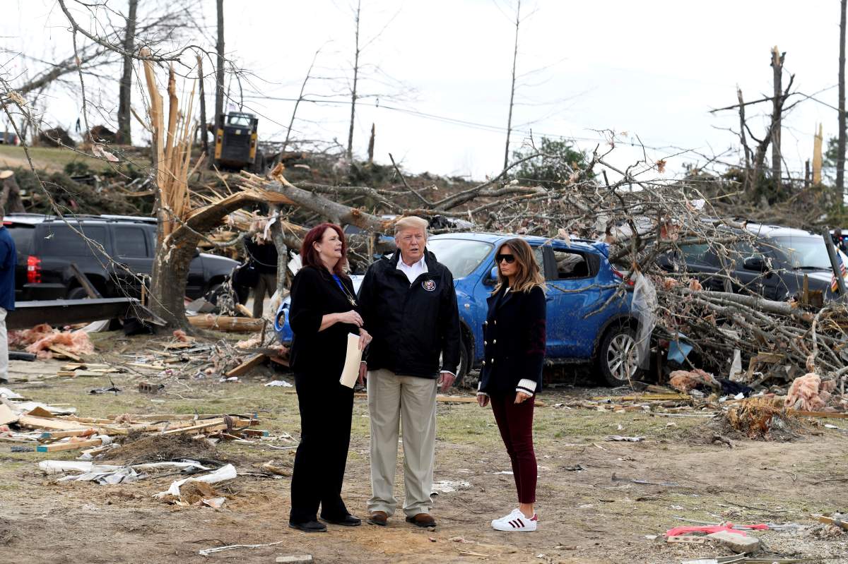 U.S. President Donald Trump and First Lady Melania Trump survey the damage and are briefed by Lee County Emergency Management Agency director Kathy Carson on the tornadoes that killed 23 people in the area earlier in the week in Beauregard, Alabama, March 8, 2019.