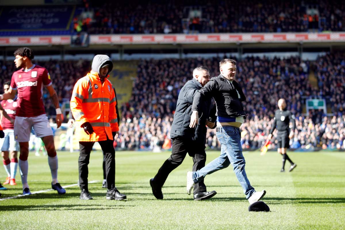 A fan is restrained by a steward after invading the pitch and attacking Aston Villa’s Jack Grealish during a match, March 10, 2019.