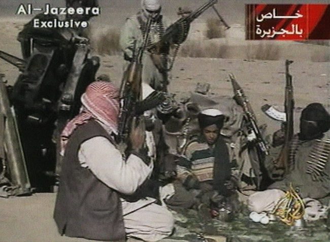 In this Nov. 5, 2001 image made from video broadcast by the Qatari-based television station Al-Jazeera, a young boy, center, identified as Hamza bin Laden, reads a poem about Taliban leader Mullah Mohammad Omar in Ghazni, Afghanistan.