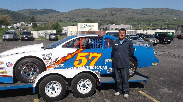 Chunming (Jack) Wang in front of a stock car.