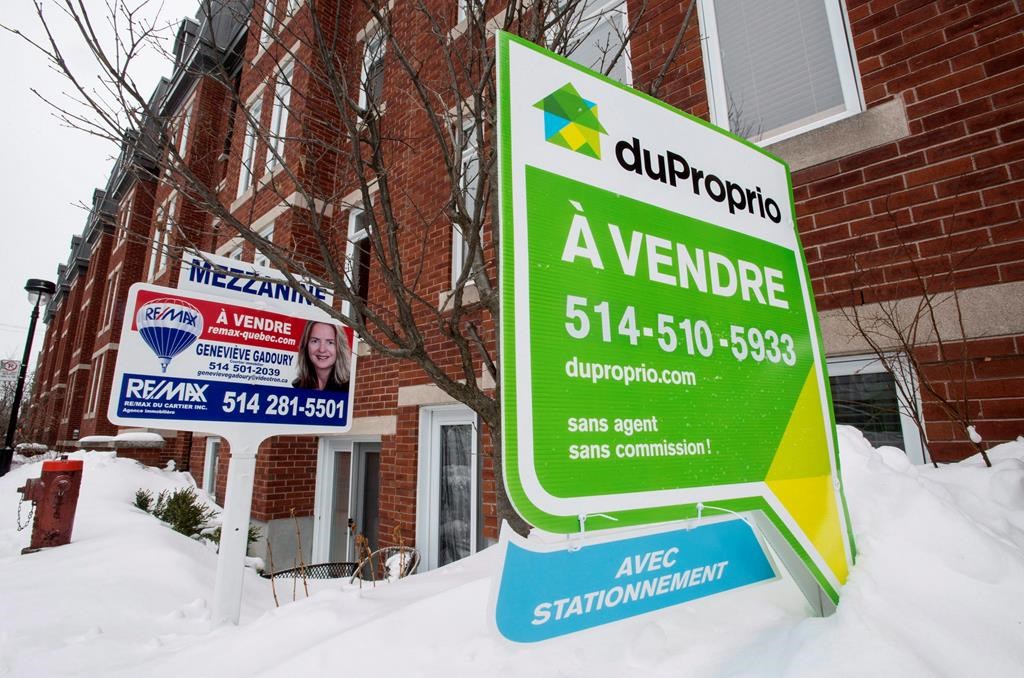 For sale signs are seen in front of a Montreal condominium, Tuesday, March 17, 2015. 