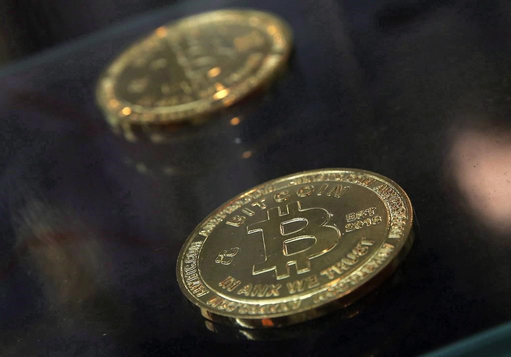 Physical bitcoins are displayed next to a Bitcoin ATM in Hong Kong, Friday, Dec. 8, 2017.