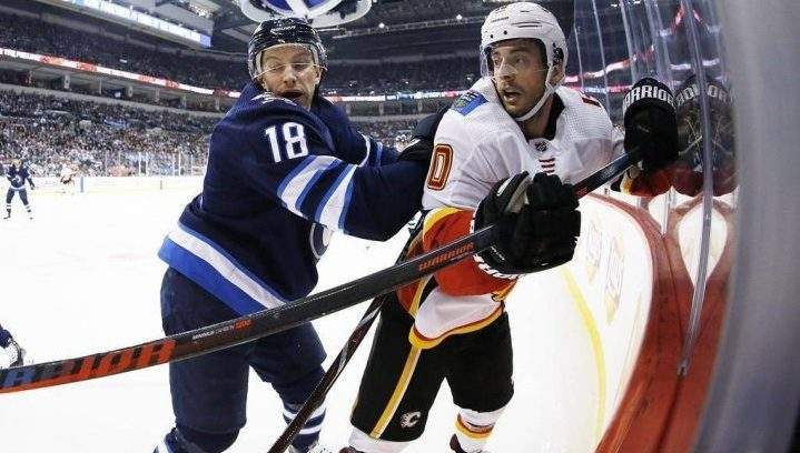 Winnipeg Jets’ Bryan Little (18) checks Calgary Flames’ Derek Ryan (10) during first period NHL action in Winnipeg on Thursday, December 27, 2018.