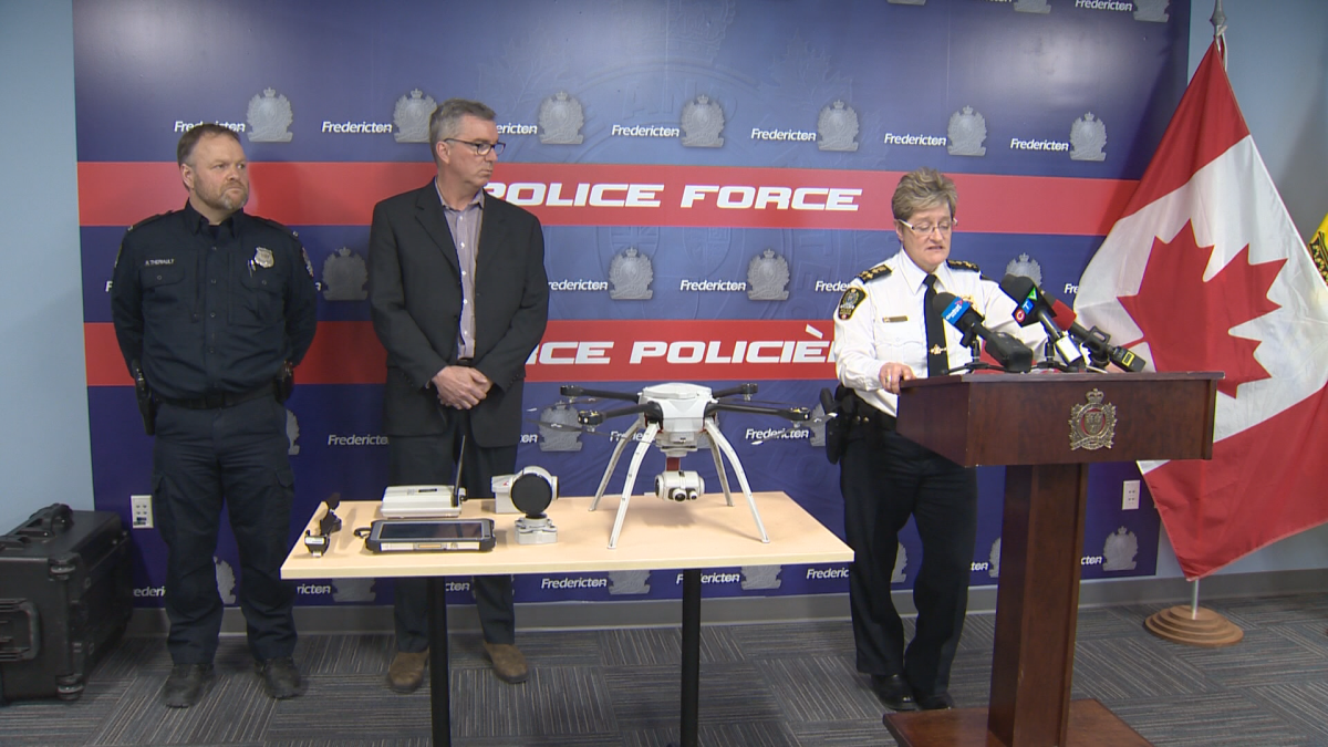 Fredericton police Chief Leanne Fitch (right) unveiling a drone donated by Fredericton-born entrepreneur Stephen Costello (middle) alongside Const. René Theriault, the force’s flight team leader.